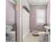 Cozy bathroom featuring lavender walls, shower, white vanity, and natural light at 909 E 15Th Ave, Tampa, FL 33605