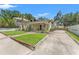 Charming home with a well-manicured lawn, a covered porch, and mature landscaping at 909 E 15Th Ave, Tampa, FL 33605