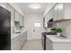 Well-lit kitchen with gray cabinets, white countertops, stainless sink, and modern appliances at 909 E 15Th Ave, Tampa, FL 33605