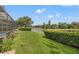 Back yard featuring landscaping, a white fence and view of the nearby lake at 9348 Deer Creek Dr, Tampa, FL 33647