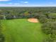 Aerial view of a baseball field surrounded by lush green space and trees in a community at 9348 Deer Creek Dr, Tampa, FL 33647