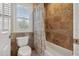 Bathroom with tiled walls, a window with shutters, and a tub with a shower curtain at 9348 Deer Creek Dr, Tampa, FL 33647
