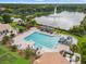 Aerial view of a community pool with a splash fountain and chairs near a lake at 9348 Deer Creek Dr, Tampa, FL 33647