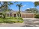 Beautiful single-story home with lush landscaping, a tile roof, and a spacious two-car garage on a sunny day at 9348 Deer Creek Dr, Tampa, FL 33647