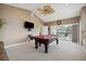 Spacious game room with a pool table and sliding glass doors leading to the pool area at 9348 Deer Creek Dr, Tampa, FL 33647