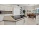 Kitchen island with sleek cooktop and white cabinets next to the breakfast nook at 9348 Deer Creek Dr, Tampa, FL 33647
