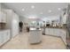 Bright, open kitchen featuring white cabinetry, a center island cooktop, and stainless steel appliances at 9348 Deer Creek Dr, Tampa, FL 33647