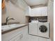 Functional laundry room featuring a utility sink, washer, and dryer at 9348 Deer Creek Dr, Tampa, FL 33647