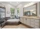 Bathroom featuring large tub, tile flooring, and large bright windows at 9348 Deer Creek Dr, Tampa, FL 33647