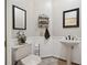 Charming powder room featuring a pedestal sink, decorative mirrors, and neutral color palette at 9348 Deer Creek Dr, Tampa, FL 33647