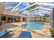 Screened swimming pool with stone patio, sun loungers, outdoor kitchen, and rear patio at 9348 Deer Creek Dr, Tampa, FL 33647