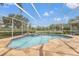 Enclosed swimming pool and spa with surrounding patio and view of the adjacent pond at 9348 Deer Creek Dr, Tampa, FL 33647