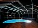 Illuminated pool and spa in screened enclosure with stone paver surround at night at 9348 Deer Creek Dr, Tampa, FL 33647