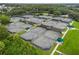 Aerial view of community tennis courts surrounded by lush greenery and trees at 9348 Deer Creek Dr, Tampa, FL 33647