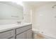 Bathroom featuring grey vanity, white countertops, and a walk-in shower with white shower walls at 10110 Pepperidge Ct, Tampa, FL 33615