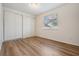 Cozy bedroom featuring light wood laminate floors, natural light, and ample closet space at 10110 Pepperidge Ct, Tampa, FL 33615