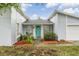 Close up of the front entrance showcasing the light blue door, lush landscaping, and decorative mulch at 10110 Pepperidge Ct, Tampa, FL 33615