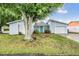 Charming single Gathering home featuring a vibrant blue front door, attached garage, and mature landscaping at 10110 Pepperidge Ct, Tampa, FL 33615