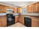 Kitchen featuring dark appliances, wooden cabinets and window at 10110 Pepperidge Ct, Tampa, FL 33615