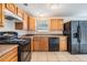Well-lit kitchen with wooden cabinets, black appliances, and tile flooring at 10110 Pepperidge Ct, Tampa, FL 33615