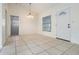 Bright living room with tile flooring, a white door, and a modern ceiling fan at 10110 Pepperidge Ct, Tampa, FL 33615