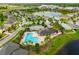 Aerial view of a neighborhood featuring a pool and lake, showcasing the community's layout and amenities at 10512 Fuzzy Cattail St, Riverview, FL 33578