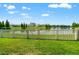 Serene backyard with a picturesque lake view and a classic white picket fence at 10512 Fuzzy Cattail St, Riverview, FL 33578