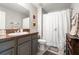 Well-lit bathroom featuring a vanity with ample counter space and a shower with a decorative curtain at 10512 Fuzzy Cattail St, Riverview, FL 33578