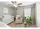 Charming Bedroom with a white crib, cozy armchair, and a bright window at 10512 Fuzzy Cattail St, Riverview, FL 33578