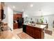 Open kitchen featuring dark wood cabinets, granite countertops, black appliances and a breakfast bar at 10512 Fuzzy Cattail St, Riverview, FL 33578