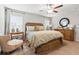 Cozy main bedroom with neutral walls, ceiling fan, and natural light from two large windows at 10512 Fuzzy Cattail St, Riverview, FL 33578