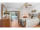 Main bedroom with hardwood floors, ceiling fan, and sliding glass doors to the pool area at 107 Halton Cir, Seffner, FL 33584