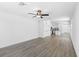 Bright open-plan living room with wood floors, ceiling fan, and a view of the modern kitchen at 11192 Humber Rd, Weeki Wachee, FL 34614