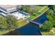 Aerial view of a building with outdoor patio, a bridge over the water, and lush greenery surrounding the building at 11224 82Nd Ave # 104, Seminole, FL 33772