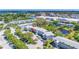 An aerial view of a condo building with well-manicured grounds and a pond, surrounded by trees and other buildings at 11224 82Nd Ave # 104, Seminole, FL 33772
