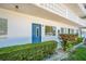 Exterior view of condo building with a blue front door and decorative lattice balcony at 11224 82Nd Ave # 104, Seminole, FL 33772