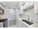 Renovated kitchen with stainless steel sink, subway tile backsplash, and white cabinets at 11224 82Nd Ave # 104, Seminole, FL 33772