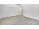 A bright, empty living room showcasing new wood-look flooring and a ceiling fan at 11224 82Nd Ave # 104, Seminole, FL 33772