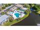 Aerial view of a community pool, tennis courts, and clubhouse next to a body of water at 11224 82Nd Ave # 104, Seminole, FL 33772
