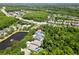 An aerial shot of a home surrounded by lush trees with a pond nearby and neighborhood at 11723 Gothic Ln, Tampa, FL 33626