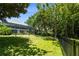 Spacious backyard featuring lush green grass, mature trees and a screened-in porch area at 11723 Gothic Ln, Tampa, FL 33626