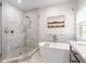 Luxurious bathroom featuring a soaking tub, walk-in shower, and marble floors at 11723 Gothic Ln, Tampa, FL 33626