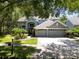 Beautiful two-story home with a three-car garage, mature landscaping, and a well-manicured lawn at 11723 Gothic Ln, Tampa, FL 33626
