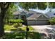 Beautifully landscaped home with palm trees, a well-maintained lawn, and a three-car garage at 11723 Gothic Ln, Tampa, FL 33626