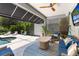 Relaxing screened-in patio with a ceiling fan, comfortable furniture, and scenic pool views at 11723 Gothic Ln, Tampa, FL 33626