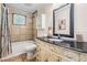 Cozy bathroom boasts vanity with granite top, shower-tub combo, and tiled floors at 118 S Manhattan Ave, Tampa, FL 33609
