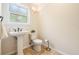 Well-lit bathroom featuring a pedestal sink, toilet, and decorative wall sconce at 118 S Manhattan Ave, Tampa, FL 33609