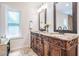 Bathroom with double sinks, granite countertops, and decorative wood cabinetry at 118 S Manhattan Ave, Tampa, FL 33609