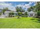 Charming single-story home featuring a well-manicured lawn, tidy landscaping, and a cozy outdoor patio with pergola at 118 S Manhattan Ave, Tampa, FL 33609
