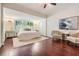 Bright main bedroom with wood floors, large window, and comfortable seating area at 118 S Manhattan Ave, Tampa, FL 33609